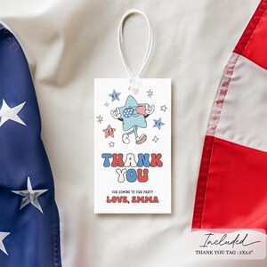 May include: A white rectangular tag with a cartoon star character wearing sunglasses and holding a small American flag. The tag reads "THANK YOU" in red and blue, with the text "FOR COMING TO OUR PARTY LOVE, EMMA" below. The tag is hanging with a white string.