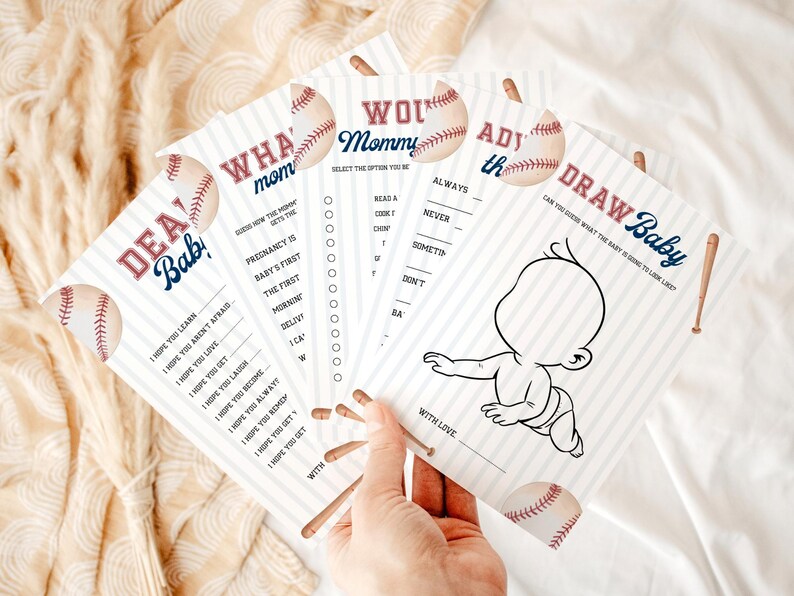 Peut inclure: Ensemble de cartes de jeu pour une baby shower sur le th&egrave;me du baseball. Les cartes pr&eacute;sentent des graphiques de baseball et du texte comme "Dear Baby" et "Draw Baby". Les cartes sont blanches avec du texte bleu et rouge.