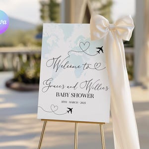 May include: A rectangular welcome sign for a baby shower featuring a light blue world map background, black cursive text reading Welcome to Grace's and Willie's BABY SHOWER 15TH - MARCH - 2025, black airplane icons, dotted flight paths, and a large white bow.