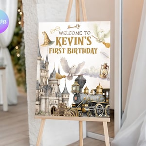 Puede incluir: Un letrero de cumpleaños estilo acuarela sobre un caballete. El letrero dice "Welcome to Kevin's First Birthday" con ilustraciones de un castillo, un tren, un búho y otros elementos mágicos. El letrero está sobre un caballete de madera.