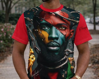 May include: Red short-sleeved t-shirt with a colourful graphic portrait of a person with chains and the text "Trayluxe Designs". The portrait has red, green, yellow, and blue colours. The person is wearing blue jeans.