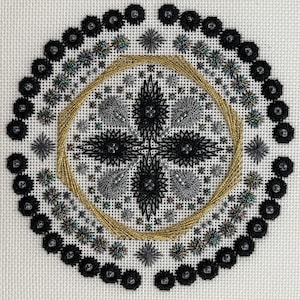 May include: A detailed needlepoint design featuring a central black cross-like pattern surrounded by intricate black and silver floral motifs. A gold beaded ring encircles the center, with a border of black beaded flowers. The background is white.