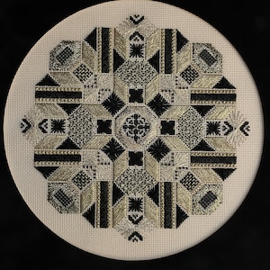 May include: A circular embroidery design featuring a geometric pattern in black and gold thread on a white canvas.