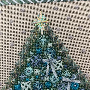 Peut inclure: Gros plan d'un sapin de No&euml;l brod&eacute; en vert et bleu avec une &eacute;toile scintillante au sommet. L'arbre est d&eacute;cor&eacute; de n&oelig;uds et de perles.