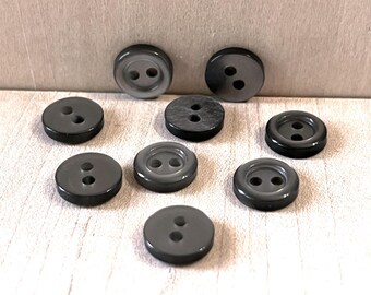 May include: Nine black two-hole buttons with a shiny finish.