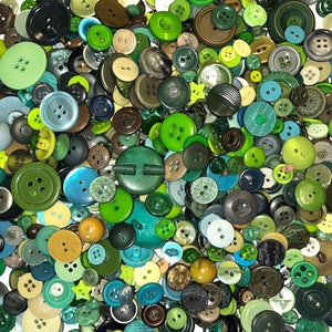 May include: A large collection of green, blue, and brown buttons of various sizes and styles. The buttons are made of plastic, metal, and wood.