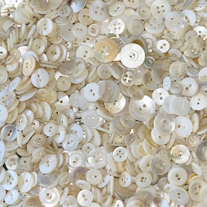 May include: A large collection of white mother of pearl buttons of various sizes and shapes.