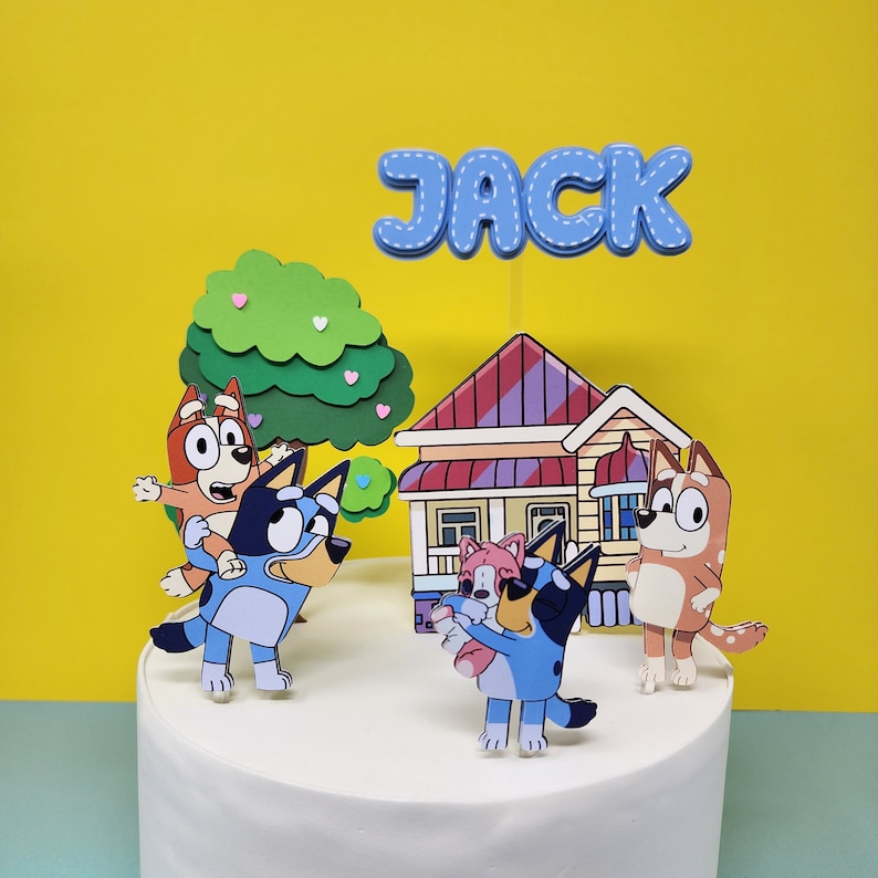 Puede incluir: Un juego de adornos para tartas azul y blanco con personajes de la serie animada Bluey. El juego incluye una casa, un &aacute;rbol y cuatro personajes. Los personajes son un perro azul heeler, un perro rojo heeler, un perro rosa heeler y un perro marr&oacute;n heeler. El juego de adornos para tartas es perfecto para una fiesta de cumplea&ntilde;os con tem&aacute;tica de Bluey. El nombre "JACK" est&aacute; escrito en letras azules en la parte superior de la tarta.