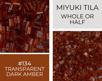 May include: A close-up image of a pile of small, translucent, dark amber colored glass beads. The beads are in the shape of a rectangle with rounded edges. The text "MIYUKI TILA WHOLE OR HALF #134 TRANSPARENT DARK AMBER" is visible in the image.