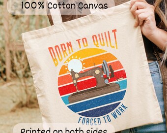 May include: Beige cotton canvas tote bag with the text "BORN TO QUILT FORCED TO WORK" in a retro design. The design features a sewing machine in a circle with a sunset background. The bag is printed on both sides.