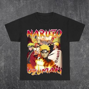 May include: Black t-shirt featuring a graphic of Naruto Uzumaki and other characters from the anime series. The design includes the word "NARUTO" in a stylized font and Japanese text. The artwork is in shades of orange, yellow, and red.