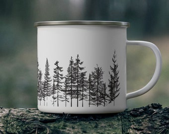May include: White enamel mug with a black silhouette of a forest printed on the side. The mug has a silver rim and handle.