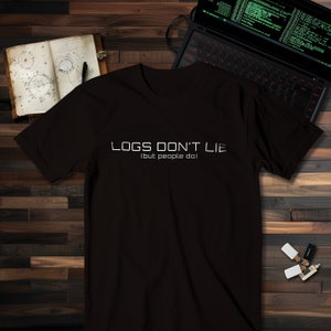 Peut inclure: T-shirt noir avec un texte blanc qui dit "LOGS DON'T LIE (but people do)"