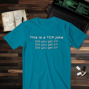 May include: A turquoise blue t-shirt with the text "This is a TCP joke Did you get it? Did you get it? Did you get it?" printed in white.