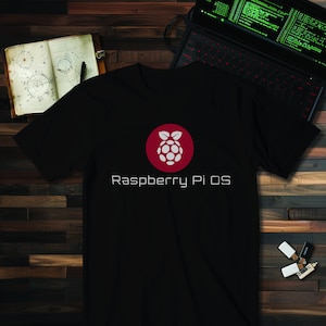 Peut inclure: T-shirt noir avec un logo Raspberry Pi blanc et le texte "Raspberry Pi OS" en blanc.