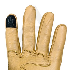 Peut inclure: Gros plan d'un gant en cuir beige avec un bout de doigt noir compatible avec les &eacute;crans tactiles. Le gant pr&eacute;sente des coutures d&eacute;taill&eacute;es et une surface textur&eacute;e. Le design du gant sugg&egrave;re qu'il est destin&eacute; au travail ou aux activit&eacute;s de plein air.