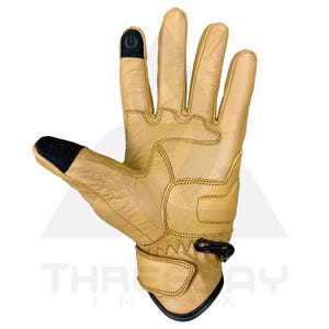 Peut inclure: Gant en cuir beige avec des touches de noir sur le bout des doigts et le poignet. Le gant pr&eacute;sente des d&eacute;tails cousus et une sangle de poignet Velcro. Les bouts des doigts ont une surface textur&eacute;e.