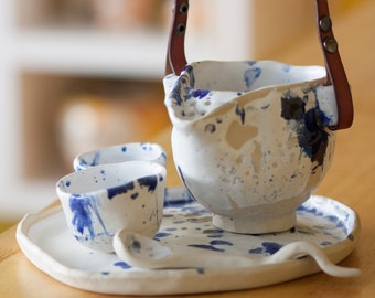 Handmade ceramic tea set in unique blue and white splashes, blending natural elegance with practical design. One-of-a-kind creation.