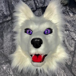 May include: White wolf fur mask with purple eyes and a red tongue. The mask has a snarling expression.