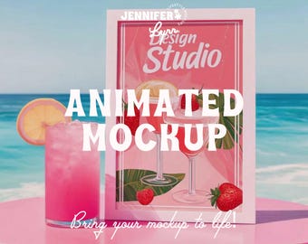 May include: A white rectangular frame displays a graphic of two cocktail glasses with strawberries and tropical leaves. A glass of pink liquid with a lemon slice sits beside the frame. Text reads JENNIFER LYNN DESIGN STUDIO ANIMATED MOCKUP.