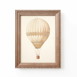 Puede incluir: Una impresión enmarcada de una ilustración vintage de un globo aerostático de color crema con una cesta de mimbre marrón.