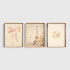 Puede incluir: Conjunto de tres impresiones de acuarela enmarcadas que representan un lazo rosa, la Torre Eiffel y una taza de té. Las impresiones tienen una estética vintage y son perfectas para una decoración del hogar con temática parisina.
