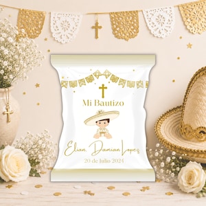 Op de afbeelding: Een witte rechthoekige snackzak met gouden accenten, voorzien van een afbeelding van een kind met een sombrero, een gouden kruis en de tekst Mi Bautizo, Elian Damian Lopez en 20 de Julio 2024. Het ontwerp bevat gouden decoratieve slingers.
