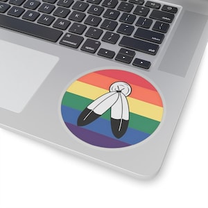 Può includere: Una bandiera arcobaleno pride con due piume bianche e nere al centro.