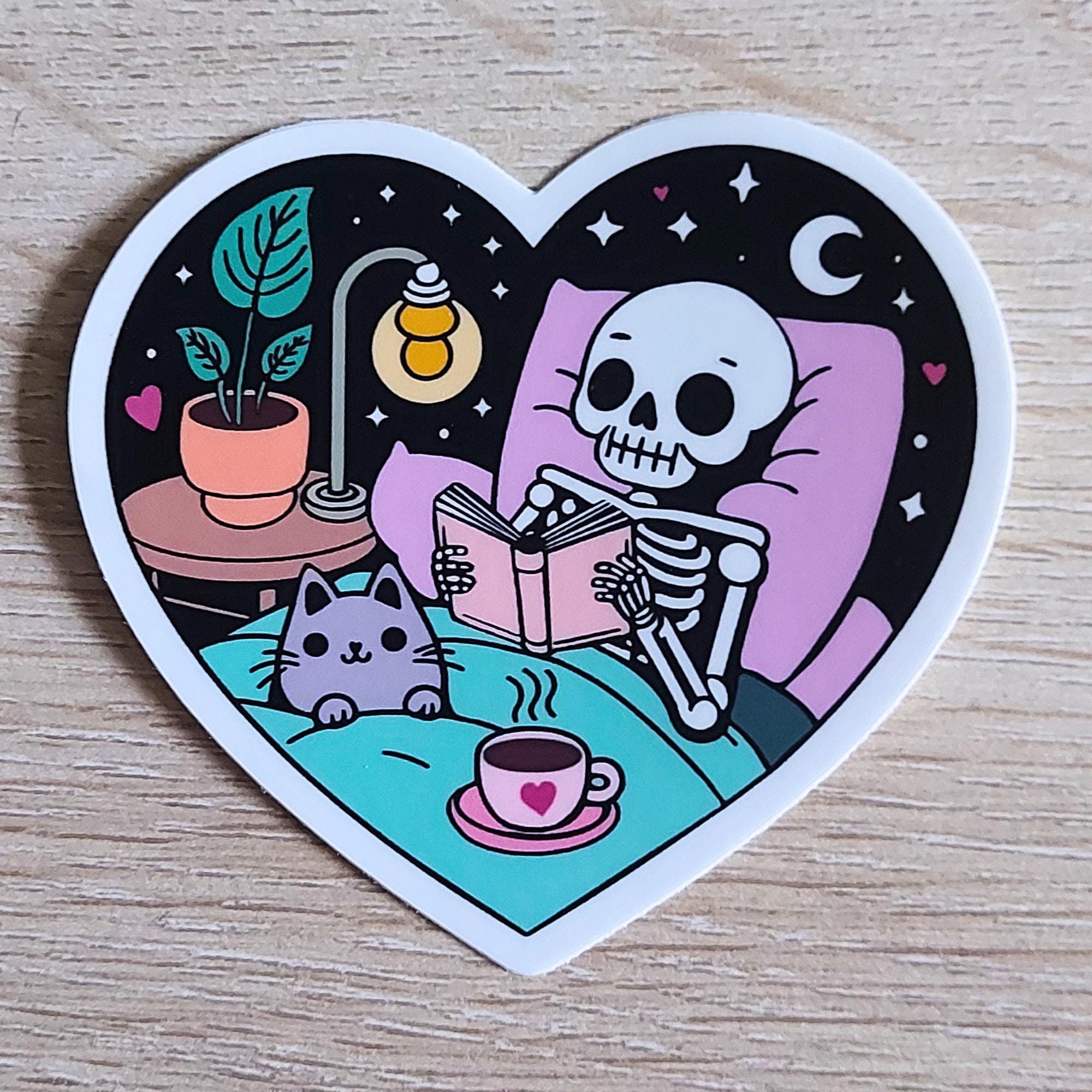 Skeleton Cat Reading Sticker | Cozy Spooky Bookish Gift for Readers, Bookworms, Book Lovers | Halloween Heart-Shaped Waterproof Vinyl Decal