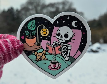 Reading Skeleton Dog Sticker | Cozy Spooky Bookish Gift for Readers, Bookworms, Book Lovers | Halloween Heart-Shaped Waterproof Vinyl Decal