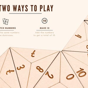 Op de afbeelding: Houten educatief spel met geometrische vormen en cijfers. De tekst "TWO WAYS TO PLAY" staat bovenaan, met instructies voor "MATCH NUMBERS" en "MAKE 10". De spelstukken zijn lichtbruin met gegraveerde cijfers.