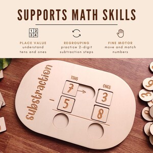 May include: Wooden subtraction math learning tool with the word "subtraction" on the side. The tool has slots for tens and ones, with wooden number tiles and the text "Supports Math Skills". Includes wooden number tiles.