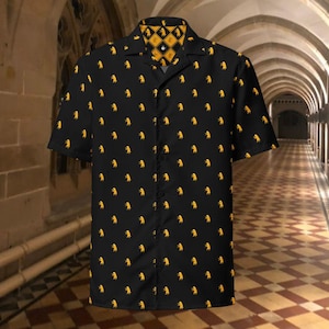 以下が含まれることがあります： 黒い半袖シャツ。黄色いライオンの繰り返し模様が特徴です。襟と内側の襟は、黄色と黒の幾何学模様のデザインです。カジュアルウェアに適しています。