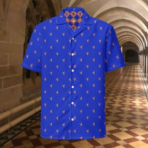 May include: A blue short-sleeved shirt with a repeating orange rabbit motif. The collar and inner lining have a geometric pattern in orange and brown. The shirt has a button-down front.
