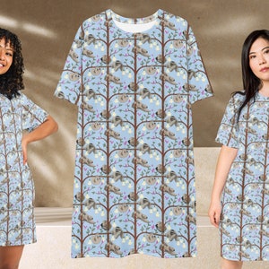 Pode incluir: Duas mulheres vestindo vestidos de camiseta azul claro com um padrão de preguiças penduradas em árvores. O padrão se repete em todo o vestido.