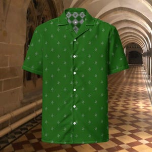 May include: Green button-up shirt with a white snake pattern. The short-sleeved shirt has a camp collar and white buttons. The collar lining features a grey and white diamond pattern. The shirt is made of a lightweight fabric.
