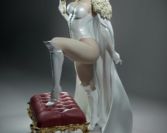 May include: A white female figurine wearing a white dress and a white cape with a fur collar. She is holding a golden goblet in her right hand and her left foot is resting on a red velvet footstool with gold trim.