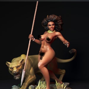 May include: A detailed figurine of a woman with dark skin, curly hair, and a spear, standing next to a lion. The woman wears a necklace and bracelet. The lion is in a crouching position, with its mouth open. The background is dark.