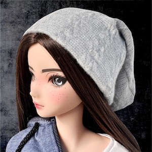 May include: A gray beanie with a slouchy fit. The beanie is made of a soft, knitted fabric.