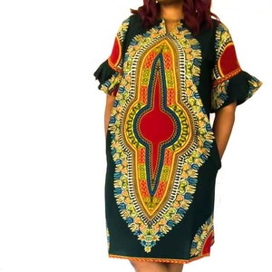 May include: A green and yellow patterned dress with a red and blue design. The dress has short sleeves with ruffles and a V-neckline.
