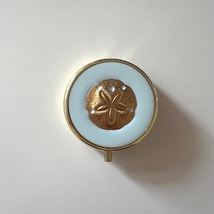Pill box with brass sand dollar on pastel blue resin: medicine storage case