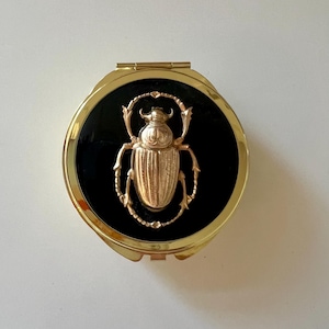 May include: A white ceramic mug with a black handle and the text "But First, Coffee" in a handwritten style. The mug is likely for hot beverages and has a glossy finish.