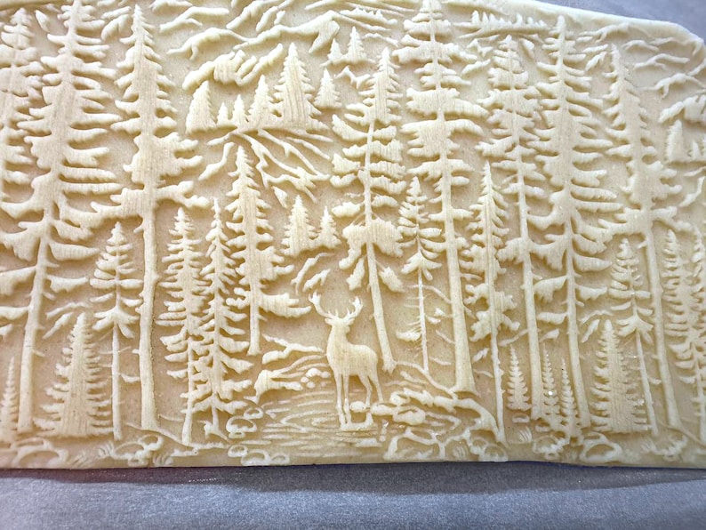 Unique rolling pin featuring a deer amidst a mountain pine forest. Perfectly engraved  for clay embossing, pottery stamping or creating beautiful  pie crusts or cookies. Elevate your baking and crafting experience with this exquisite ceramic tool.