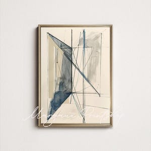 May include: Abstract art print in a gold frame. The artwork features geometric shapes and lines in shades of blue, gray, and beige. The design includes intersecting lines and angular forms, creating a modern and minimalist aesthetic.