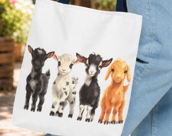 May include: A white tote bag with dark blue handles featuring a graphic illustration of four baby goats in a row. The goats are colored black, white with black spots, black with a white face stripe, and light brown, standing on a plain white background.