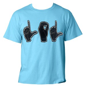以下が含まれることがあります： 水色のTシャツ。黒い手のジェスチャーで「LOL」という単語が書かれています。手は白いステッチで縁取られています。このシャツはクルーネックで半袖です。
