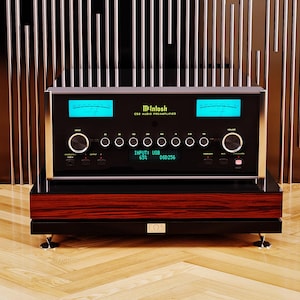 May include: A McIntosh C52 audio preamplifier, featuring a black faceplate with blue illuminated meters and control knobs. The unit sits atop a wooden stand with a dark finish. The display shows "INPUT: USB 65% DSD256".