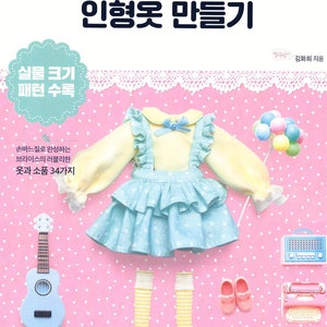 May include: A book cover with a pink background and a white lace border. The title is "Malgalryangi's Cute Doll Clothes" in Korean. The cover features a doll wearing a yellow shirt, blue skirt, and pink shoes. The book includes 34 patterns for making doll clothes.
