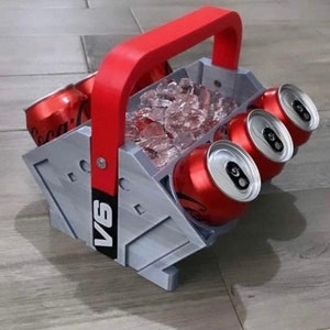 May include: A gray and red six-pack cooler with a handle. The cooler is filled with ice and has four red cans inside. The cooler has the text "V6" printed on the side.