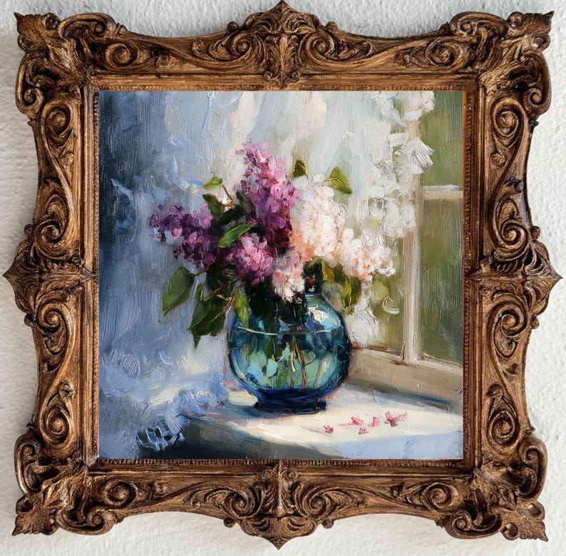 May include: An oil painting in a decorative, ornate, antique-style gold frame. The artwork depicts a bouquet of purple and white lilac flowers arranged in a round, translucent blue glass vase, positioned on a surface near a window with white curtains.